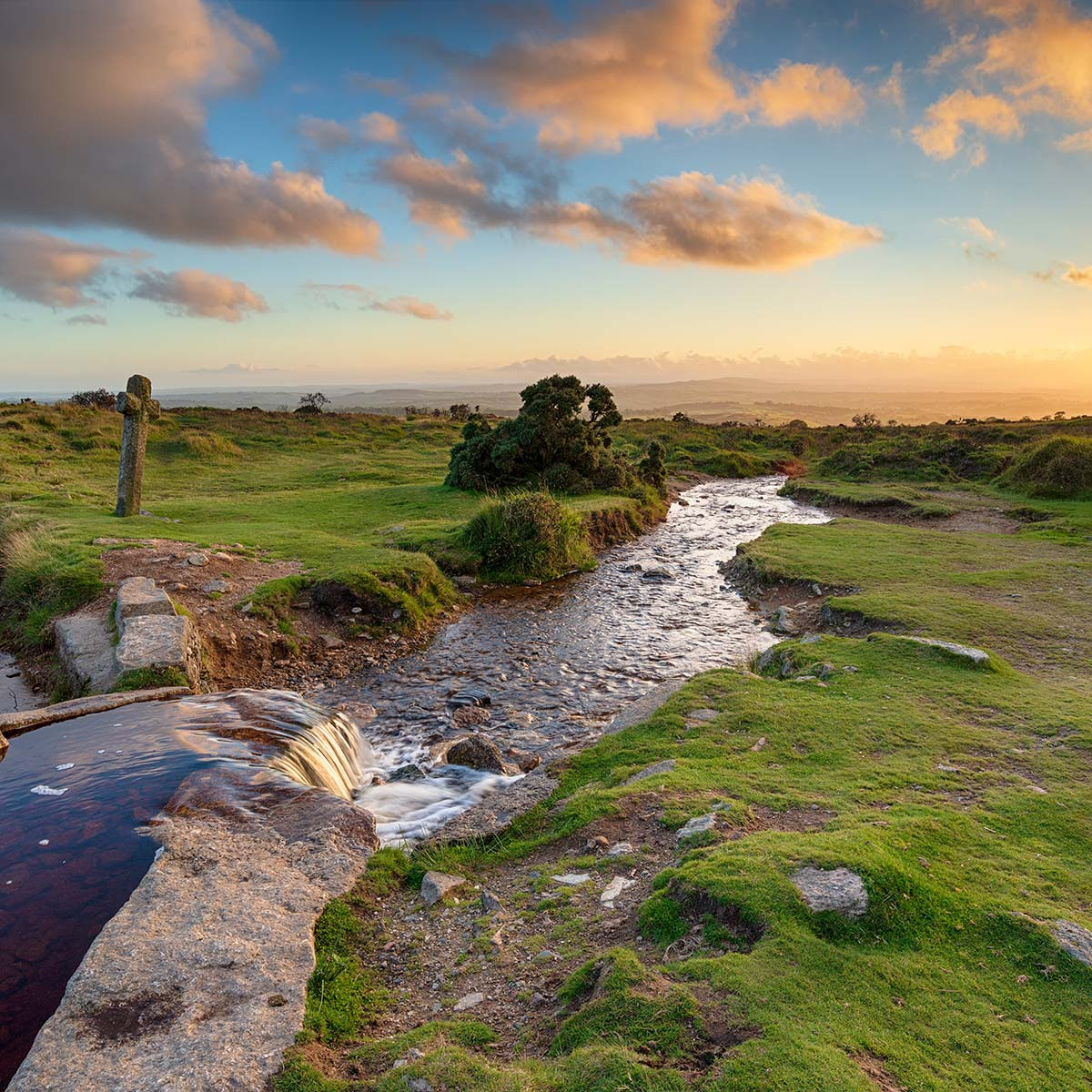 Sunset with granite cross over Dartmoor